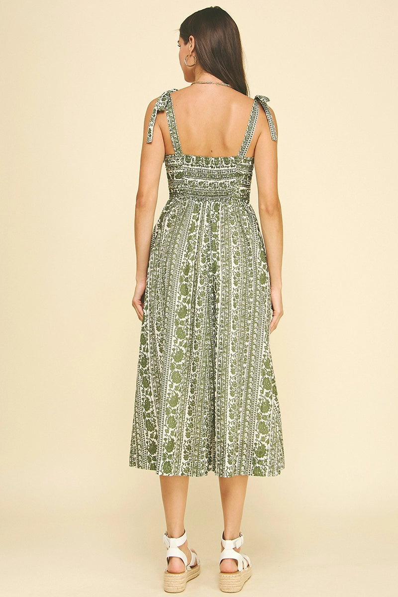 Woman wearing a green patterned dress on a beige background