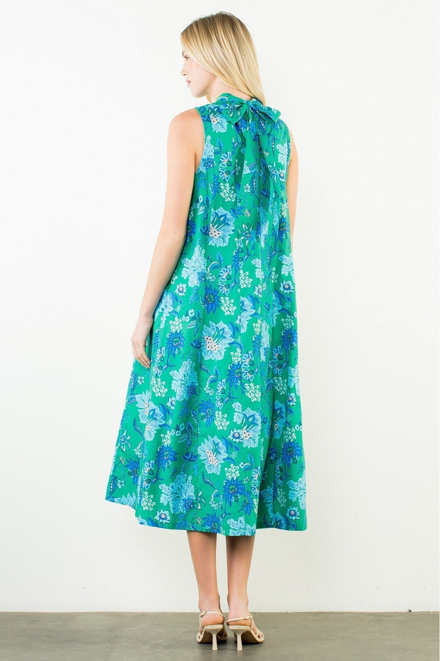 Woman wearing a green floral dress on a white background