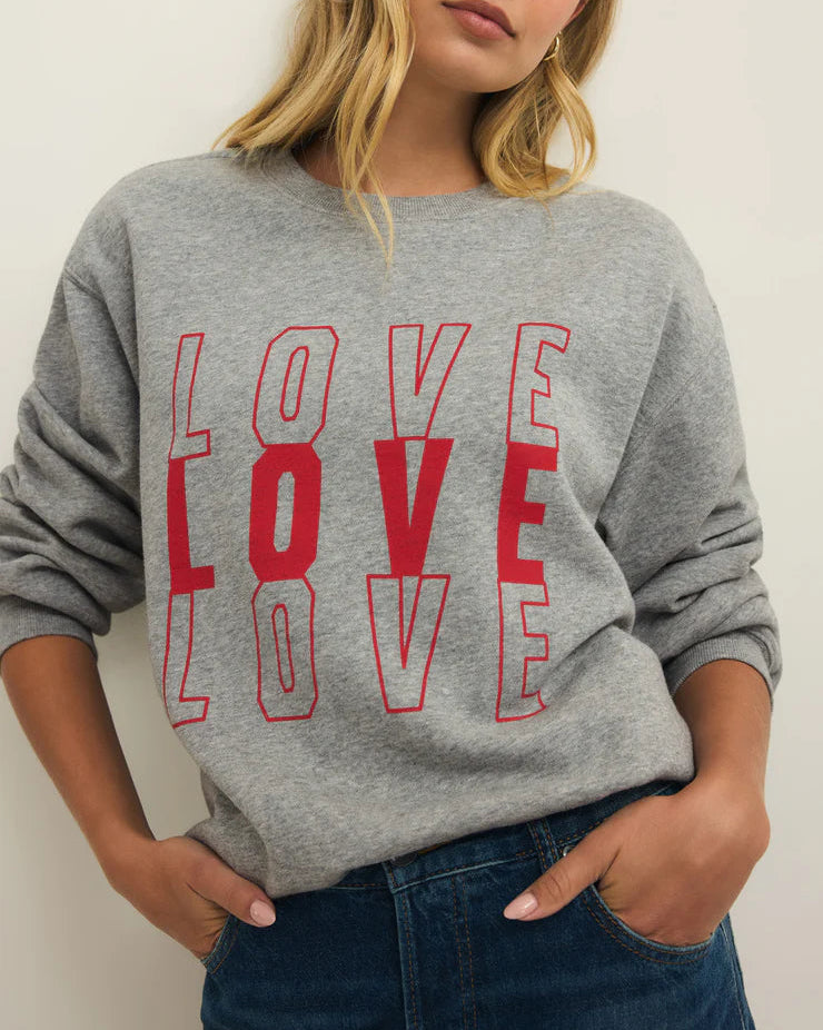 Person wearing a gray sweatshirt with 'LOVE' printed in red.
