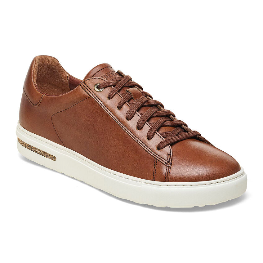 A pair of brown Birkenstock men's leather sneakers with a lace-up closure, contoured footbed, and natural rubber sole.