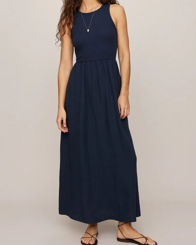 Woman wearing a navy blue sleeveless dress on a beige background