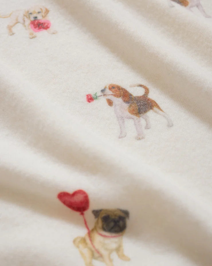 Fabric with dog illustrations holding balloons on a beige background