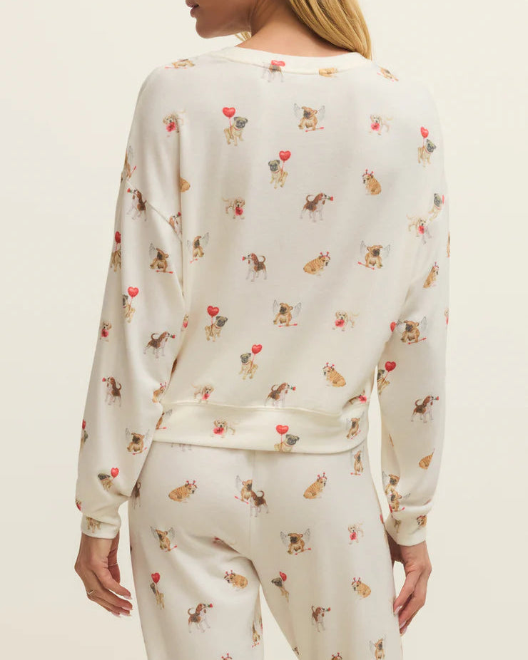 Woman wearing a cream-colored pajama set with animal print on a plain background