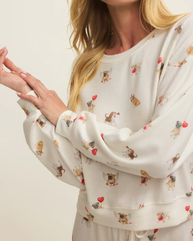 Woman wearing a white long-sleeve top with animal print on a plain background