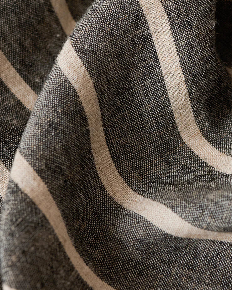 Close-up of textured fabric with beige lines on a dark background
