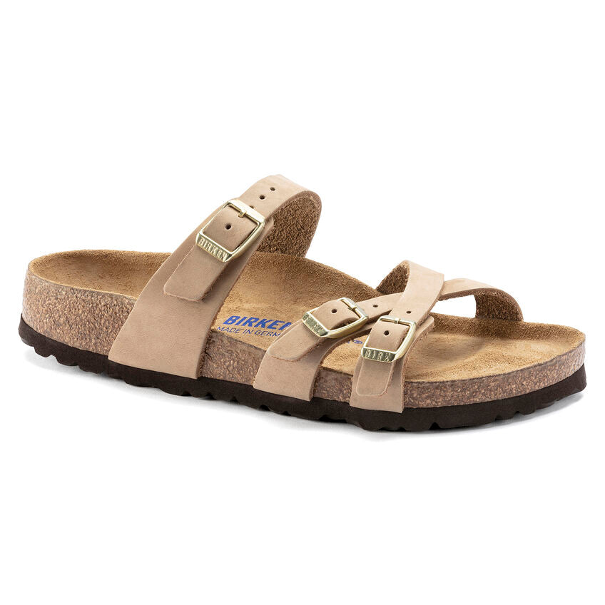 A pair of Birkenstock Franca Soft Footbed sandals in beige color, featuring slim crisscrossed straps and an ankle strap with a metal pin buckle.