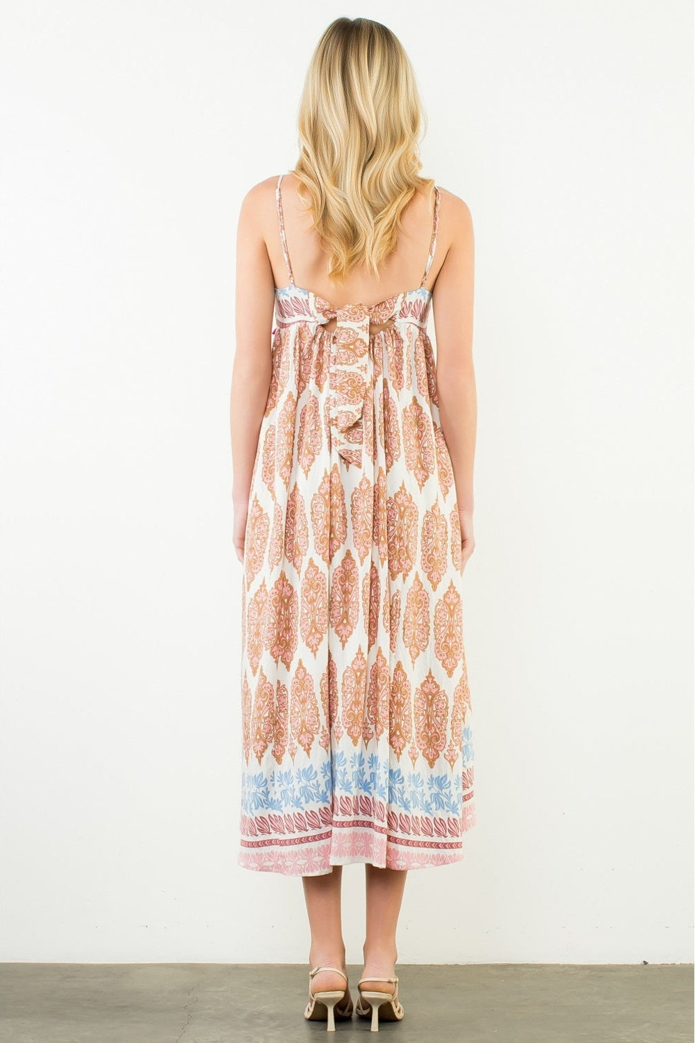 Woman wearing a patterned dress on a white background